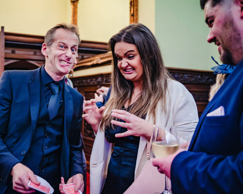 wedding reception magician wedd Wedding guests totally engaged in the magic during the wedding celebrations during the evening cocktail hour.