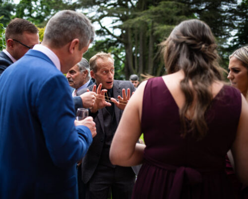 bourton hall wedding magic Brett Sirrell performing a trick using elastic bands to a bridesmaids and wedding guests at a hotel wedding venue